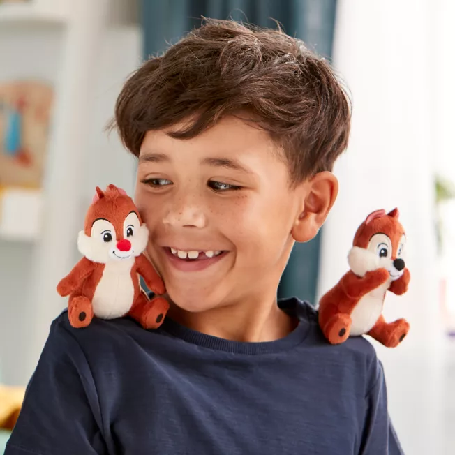 em bé cười tươi khi chơi với 2 chú gấu bông sóc